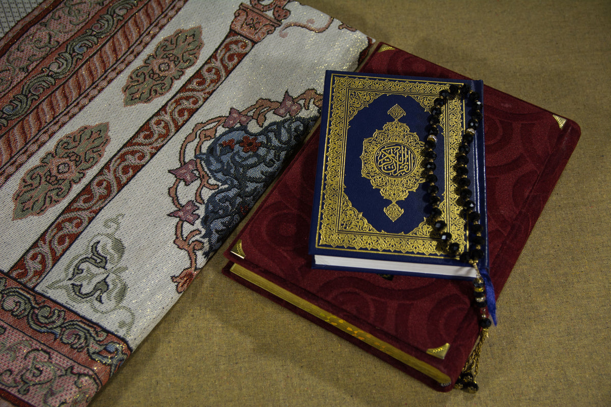 Smart prayer mat with LED indicators next to a traditional woven prayer rug